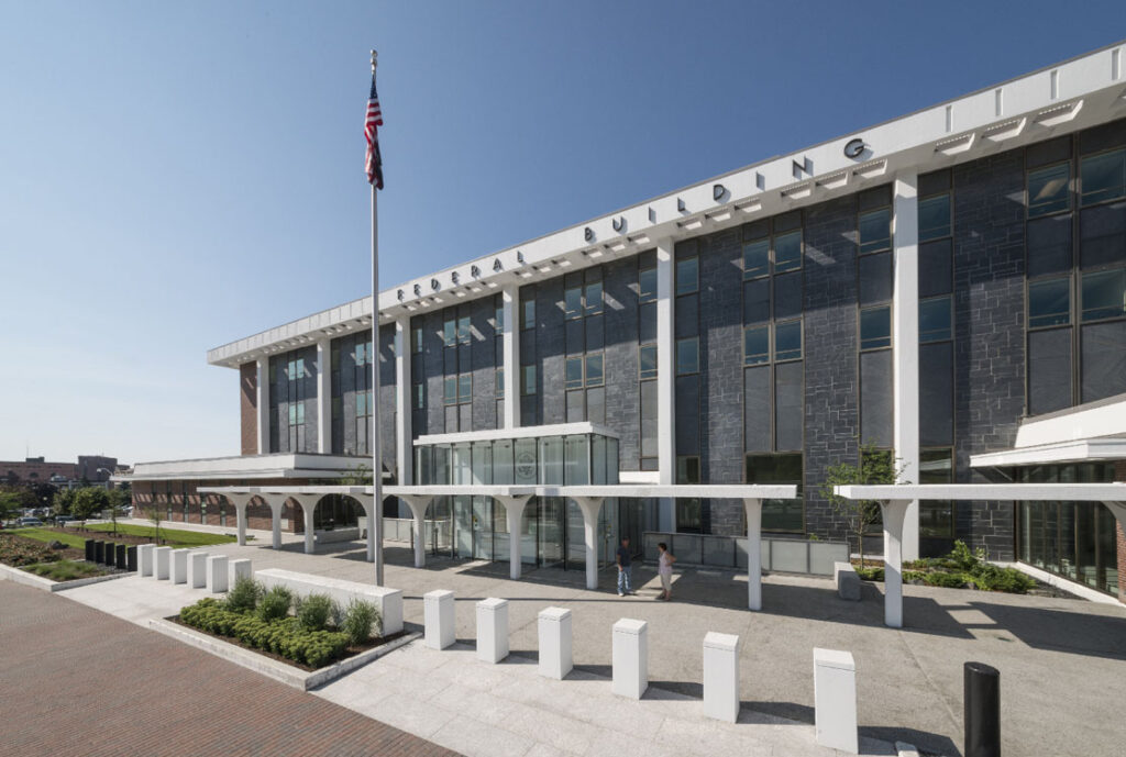 An aerial view of a building with a flag in front of it.