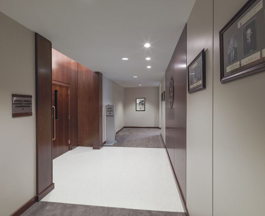 A hallway with wooden walls and framed pictures.