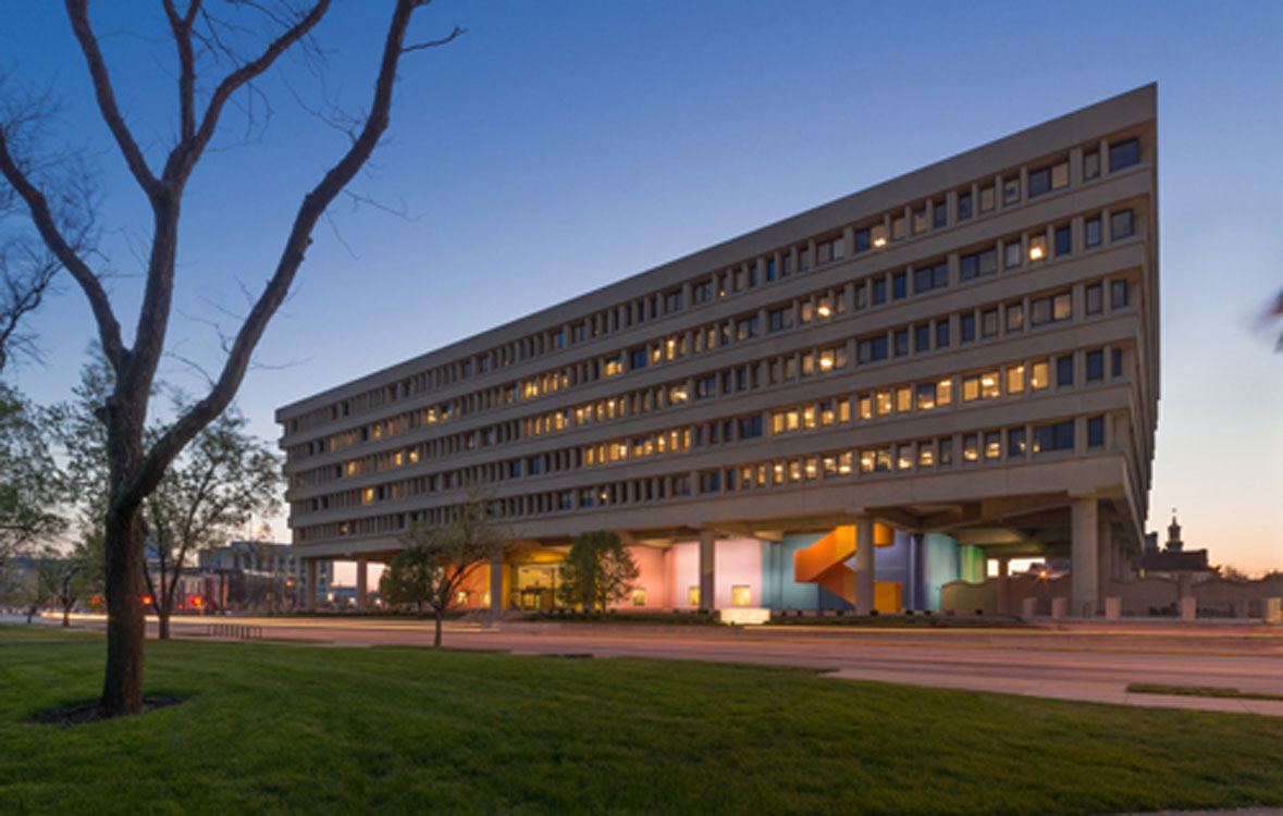 A large building with a colorful facade at dusk.