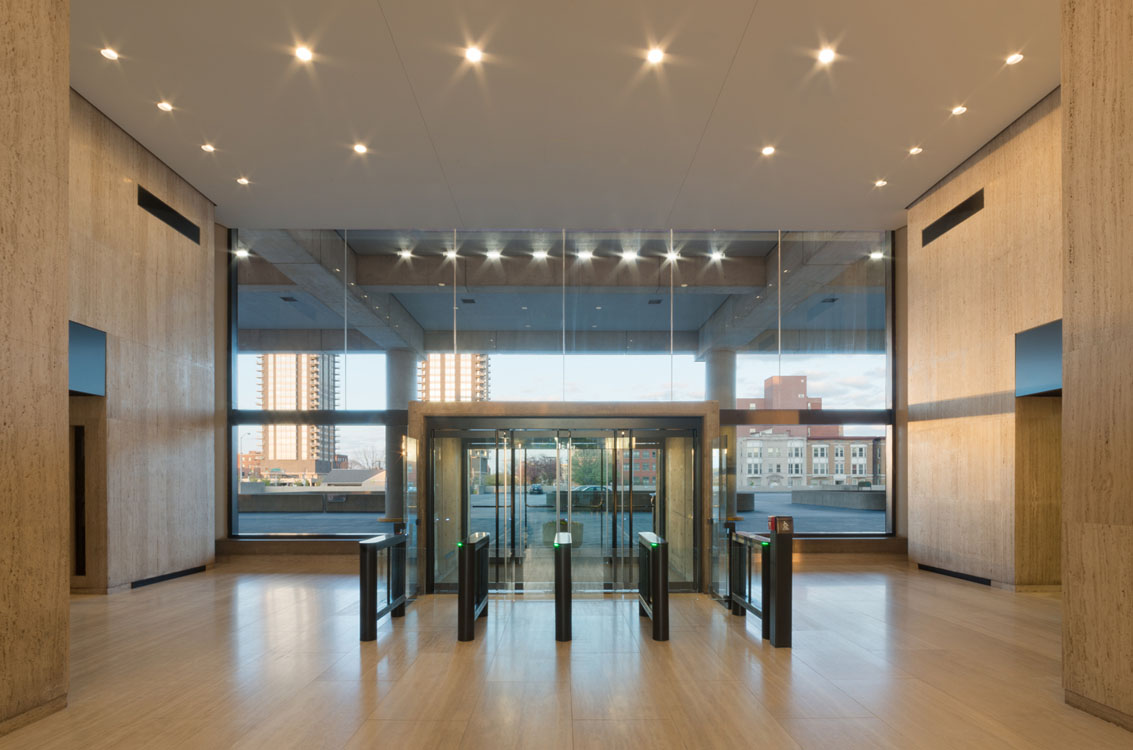 Le hall d'entrée d'un grand immeuble avec des portes vitrées.