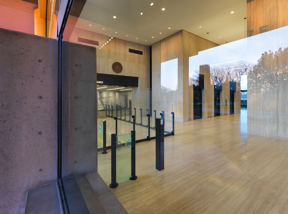 A glass wall in a building with a view of a mountain.