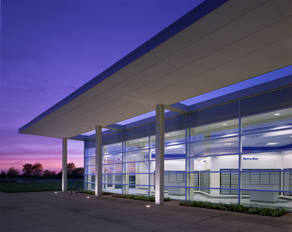 Un grand bâtiment de verre au crépuscule.