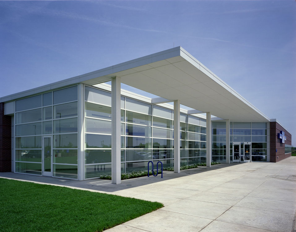 A large building with glass windows and a grassy area.