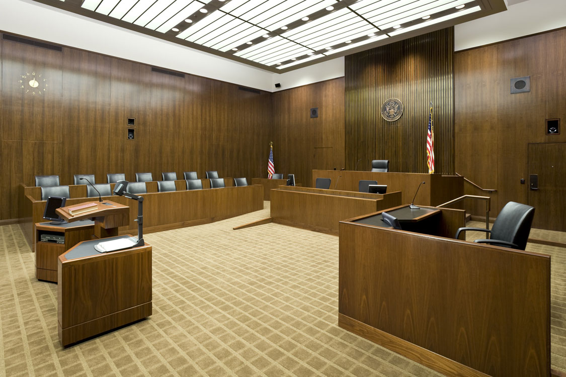 A courtroom with a desk and chairs.