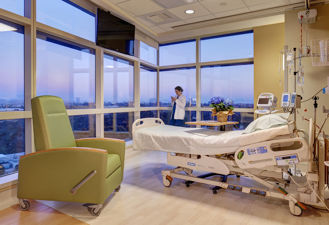 A green chair in a hospital room.