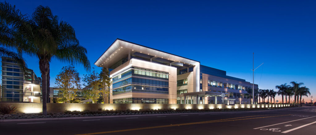 A modern office building lit up at night.
