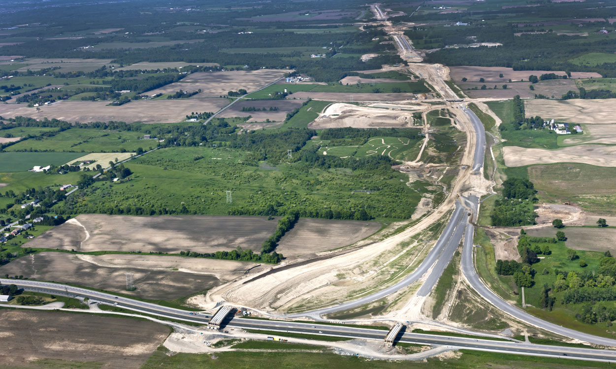 An aerial view of a highway over a field.