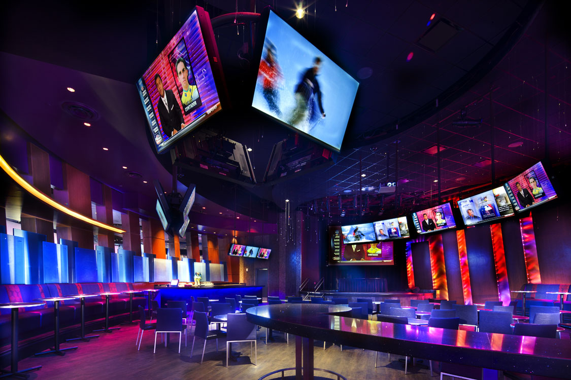 A bar with a large number of televisions.