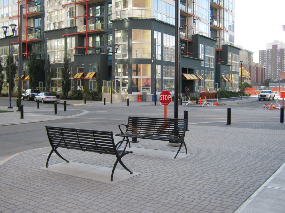 Deux bancs sur un trottoir.