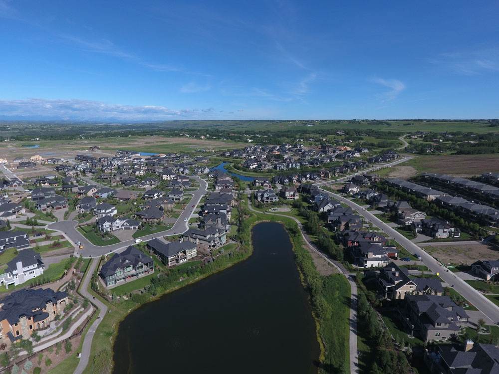 An aerial view of a residential neighborhood with a pond.