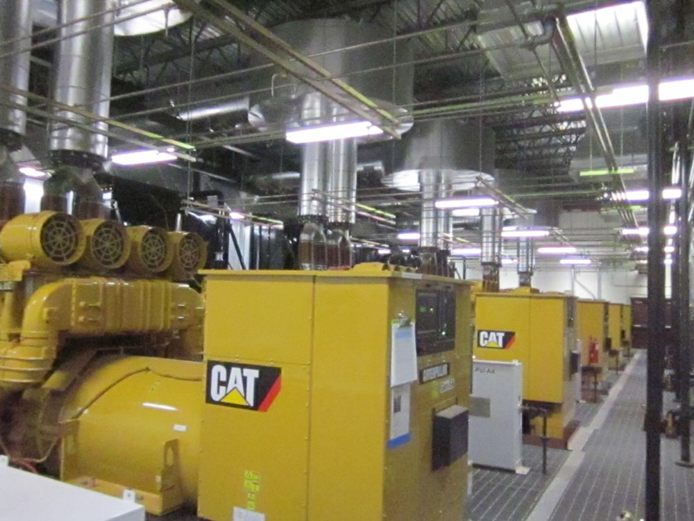 A room full of yellow generators in a factory.