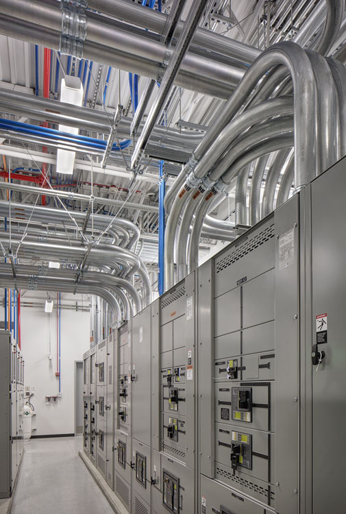 A large electrical room with pipes and wires.