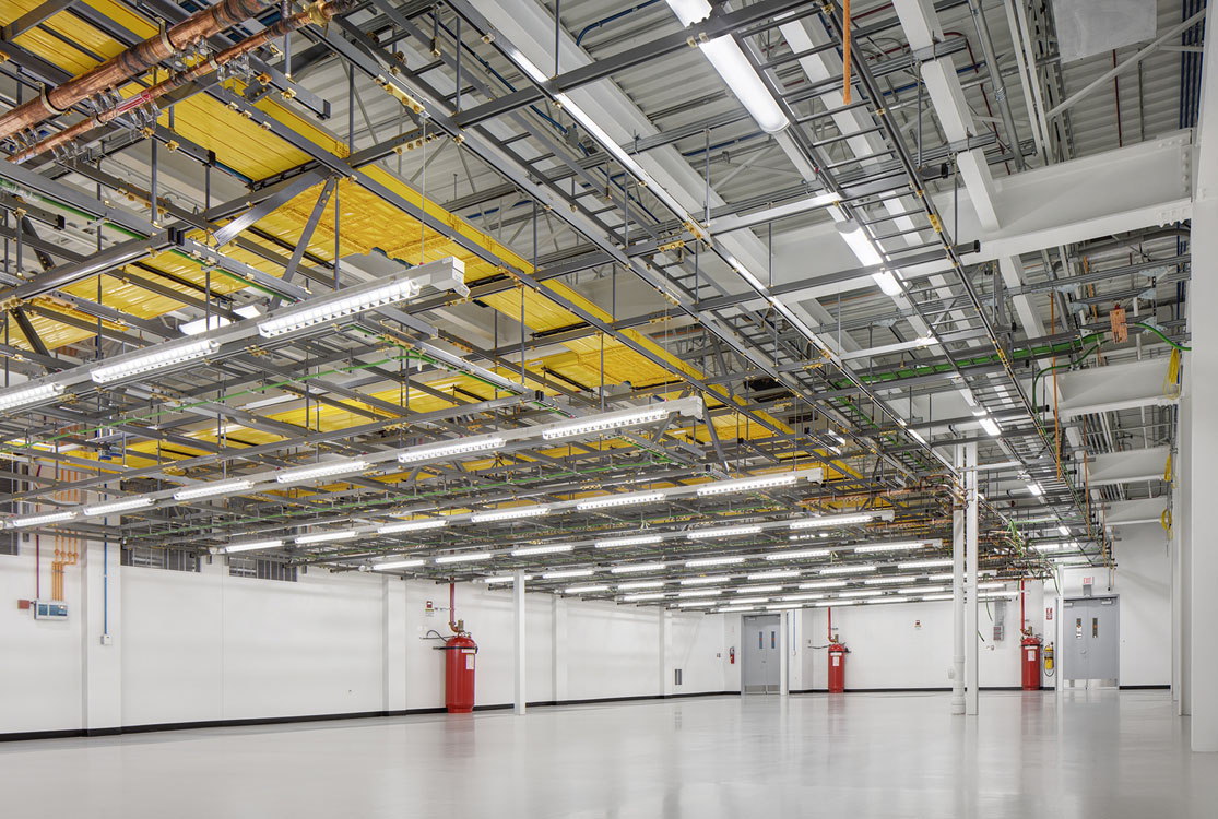 A large warehouse with many wires and yellow fire hydrants.