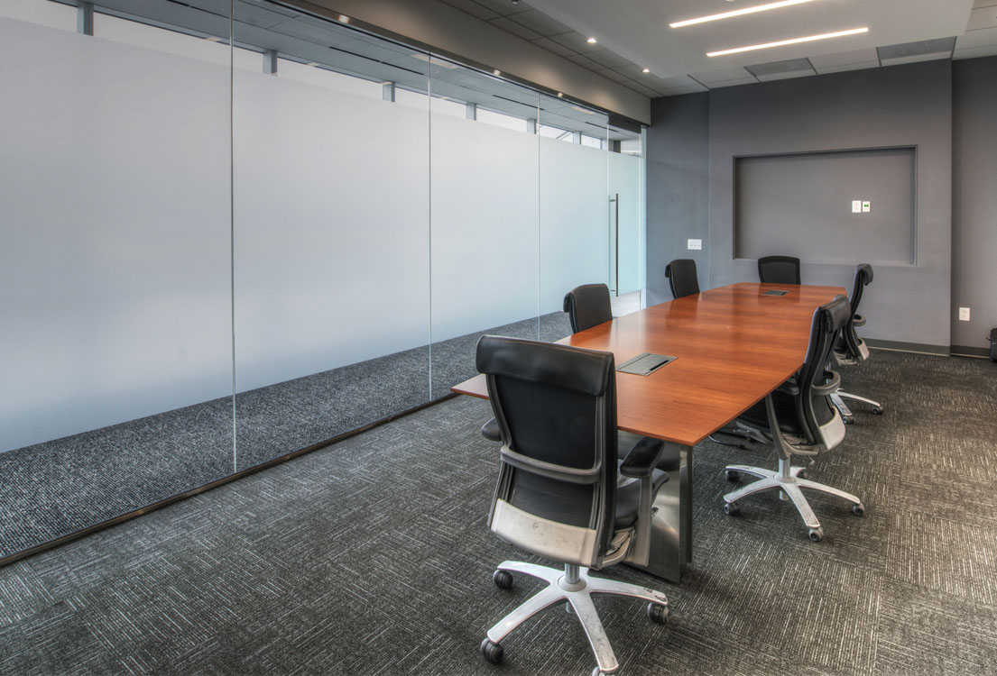 A conference room with glass walls and chairs.