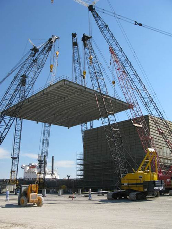 A crane is lifting a large piece of metal.