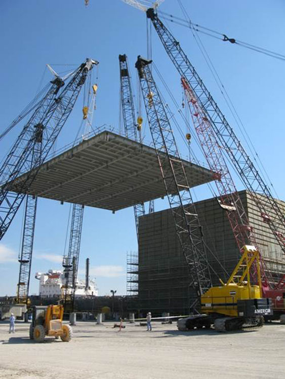 Une grue soulève un gros morceau de métal.