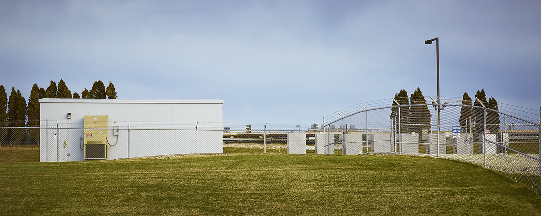 A white building next to a grassy field.