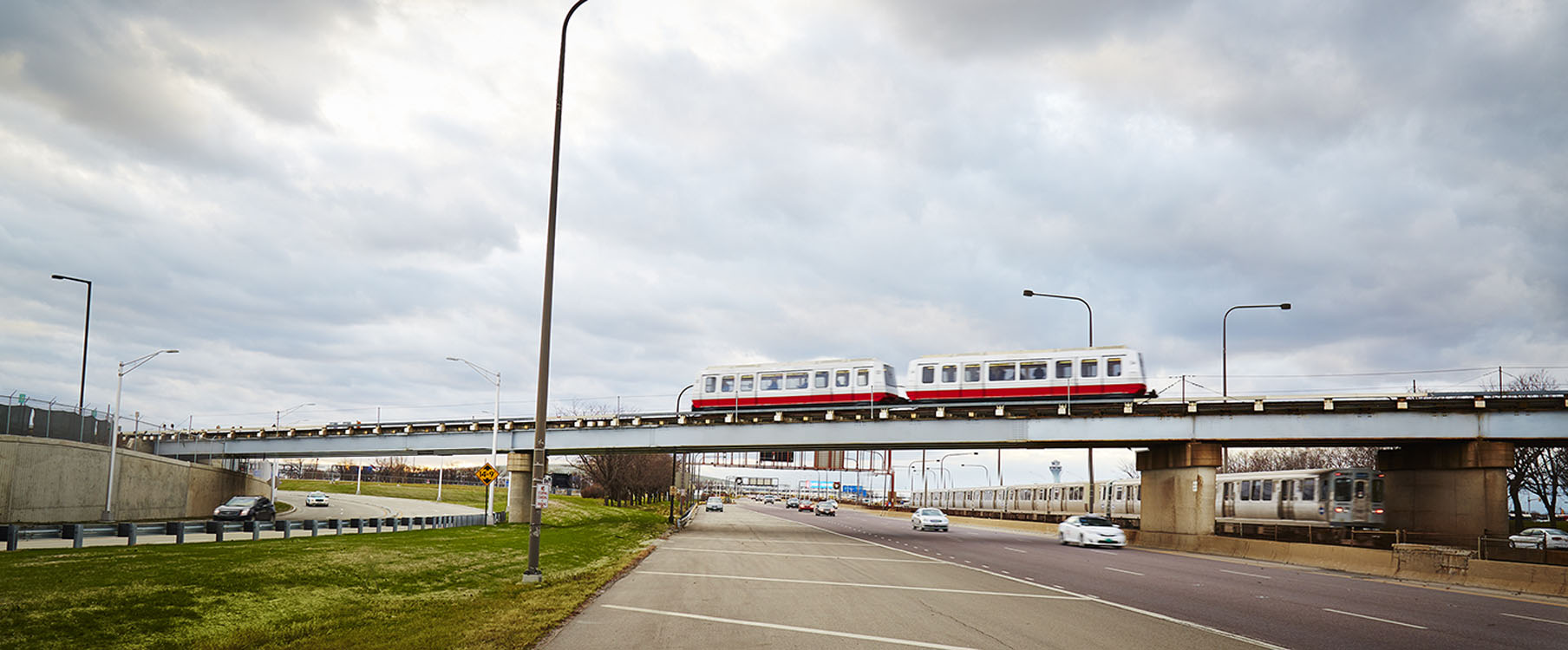 A red and white train traveling over a bridge.