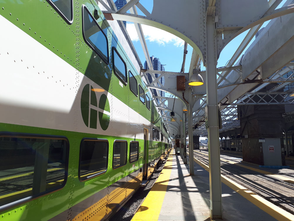 A green and white train at a train station.