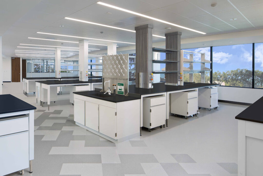 Un laboratoire blanc avec des comptoirs et des fenêtres noirs.