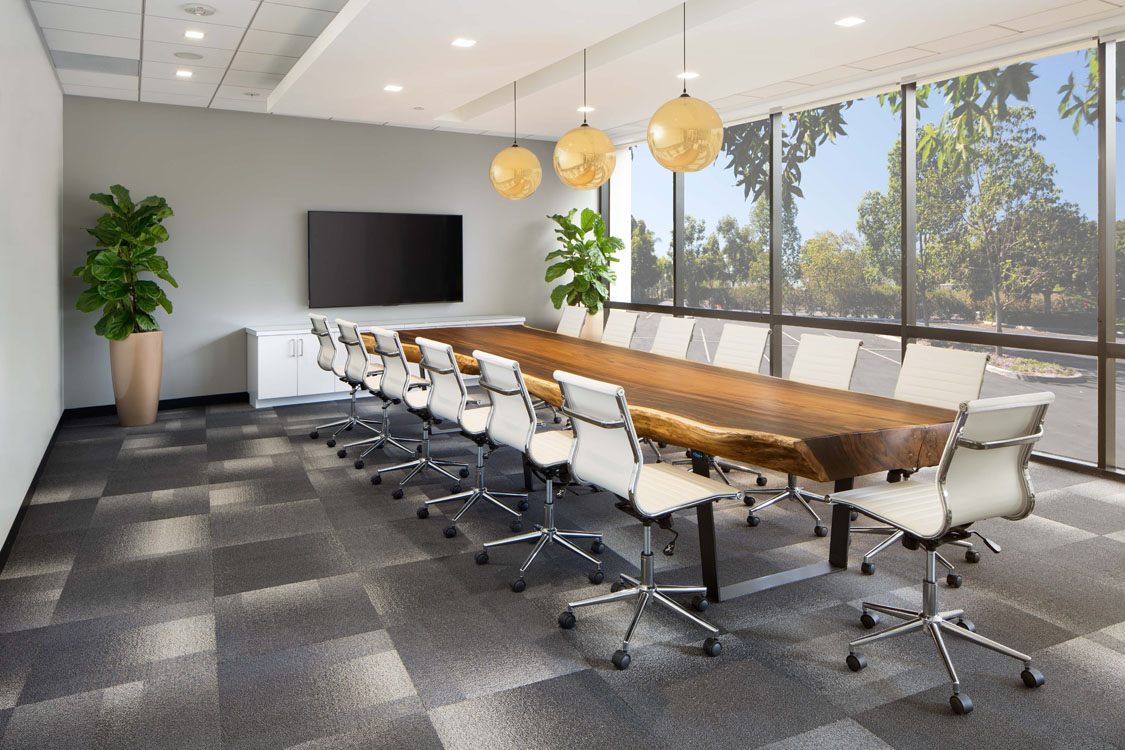 Une salle de conférence avec une grande table et des chaises.