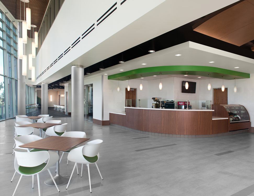 A lobby with tables and chairs in a modern building.