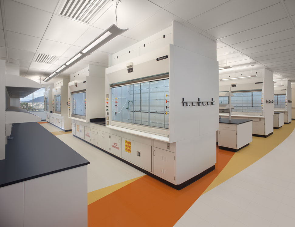 Une image d’un laboratoire avec des comptoirs blancs et des murs orange.