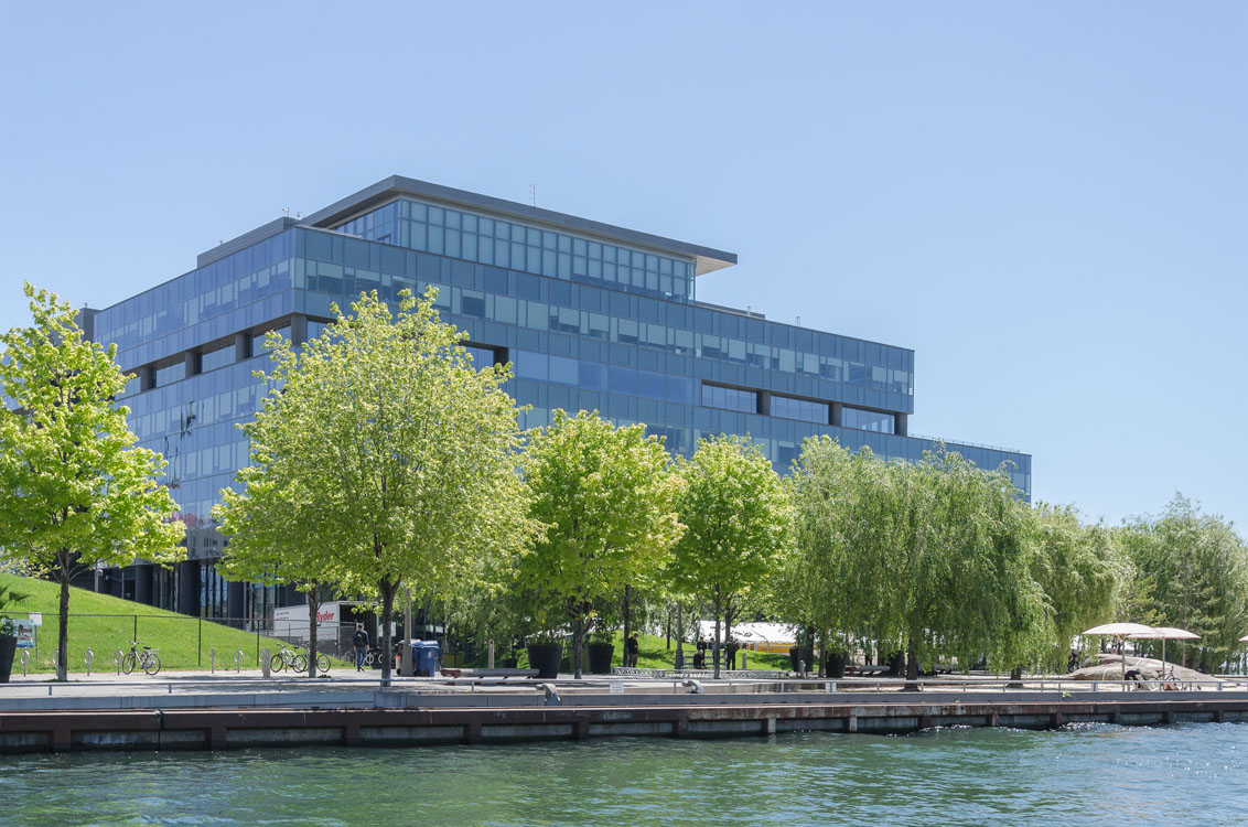 A large office building next to a body of water.