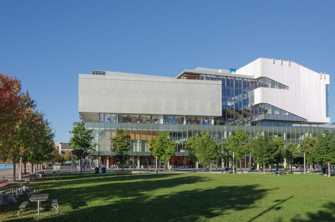 Un grand bâtiment avec un espace gazonné devant.