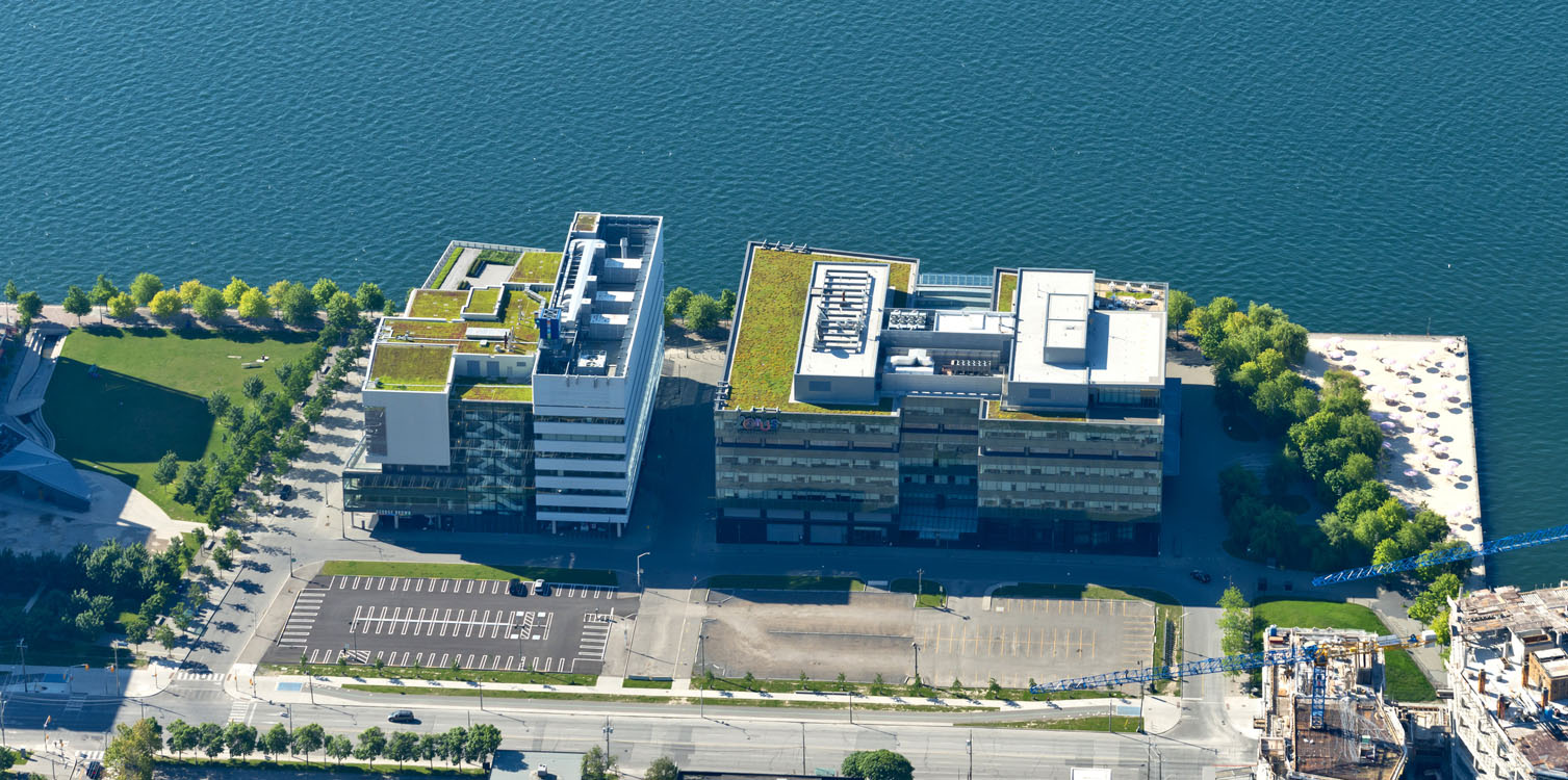 An aerial view of an office building near a body of water.