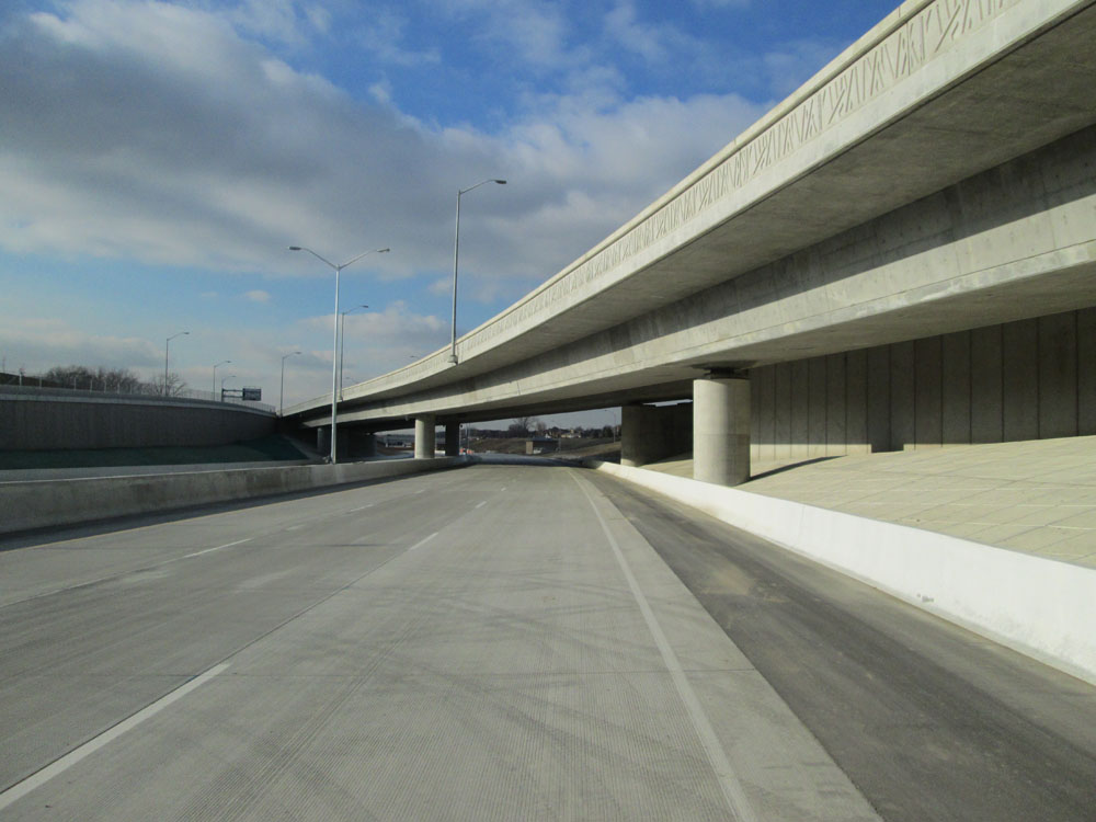 A concrete bridge over a highway.