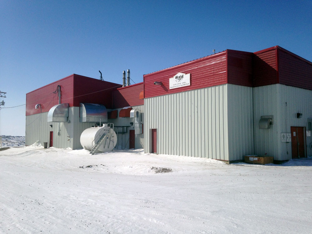 A red and white building with a snow covered roof.