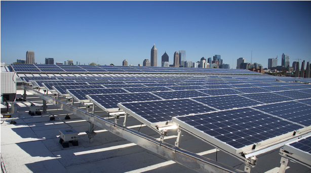 Solar panels on a roof with a city in the background.