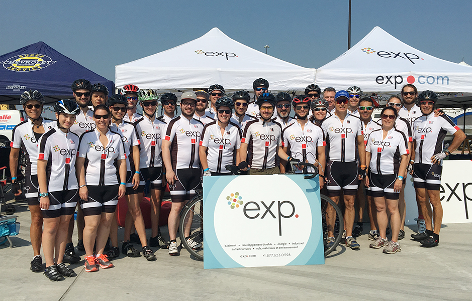 A group of cyclists posing in front of a tent.