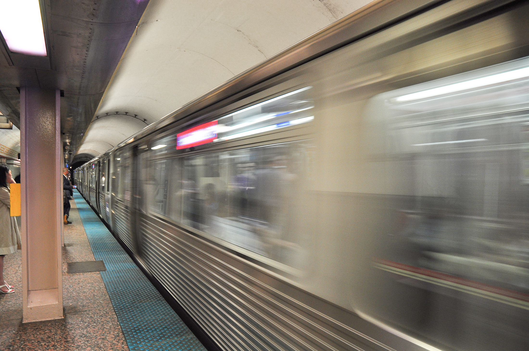 A modernized train is moving at a train station.