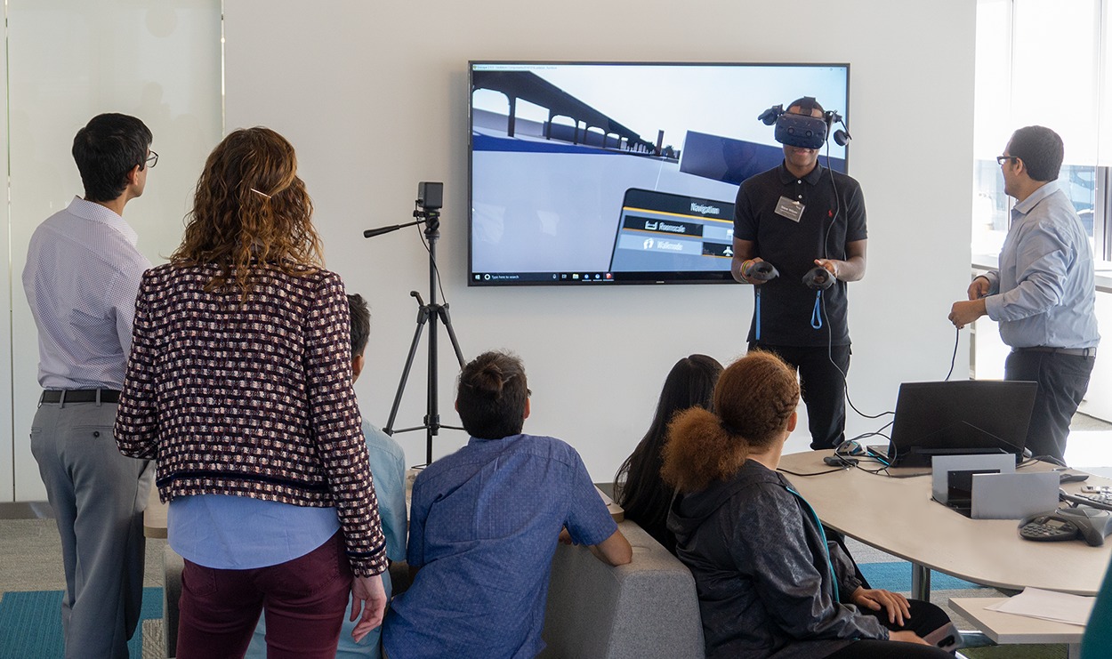 A group of people watching a vr video in a conference room.
