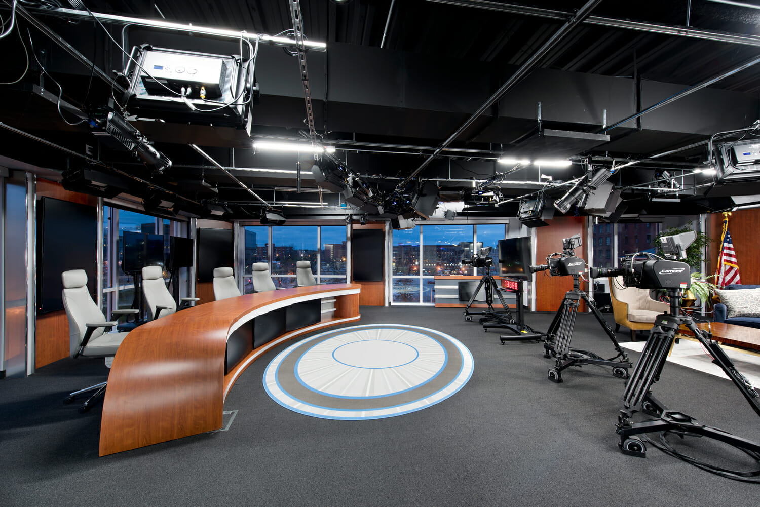 A television studio with a circular table and chairs.