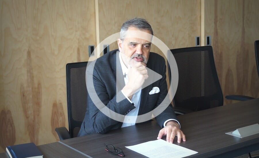 Un homme en costume assis à un bureau.