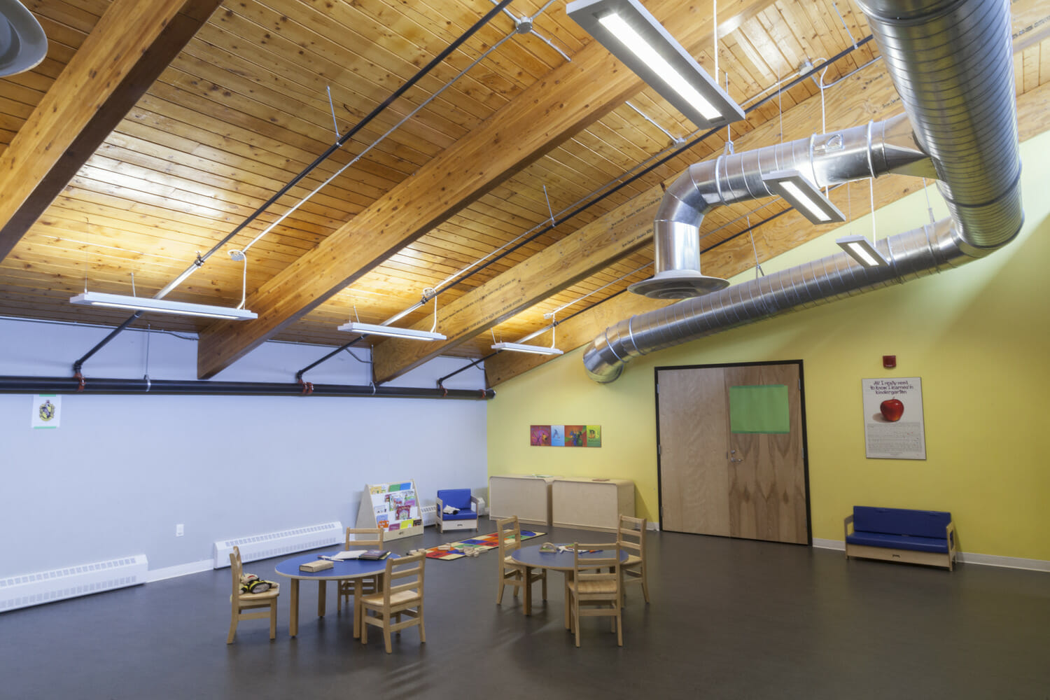 Une pièce avec tables et chaises et un plafond en bois.