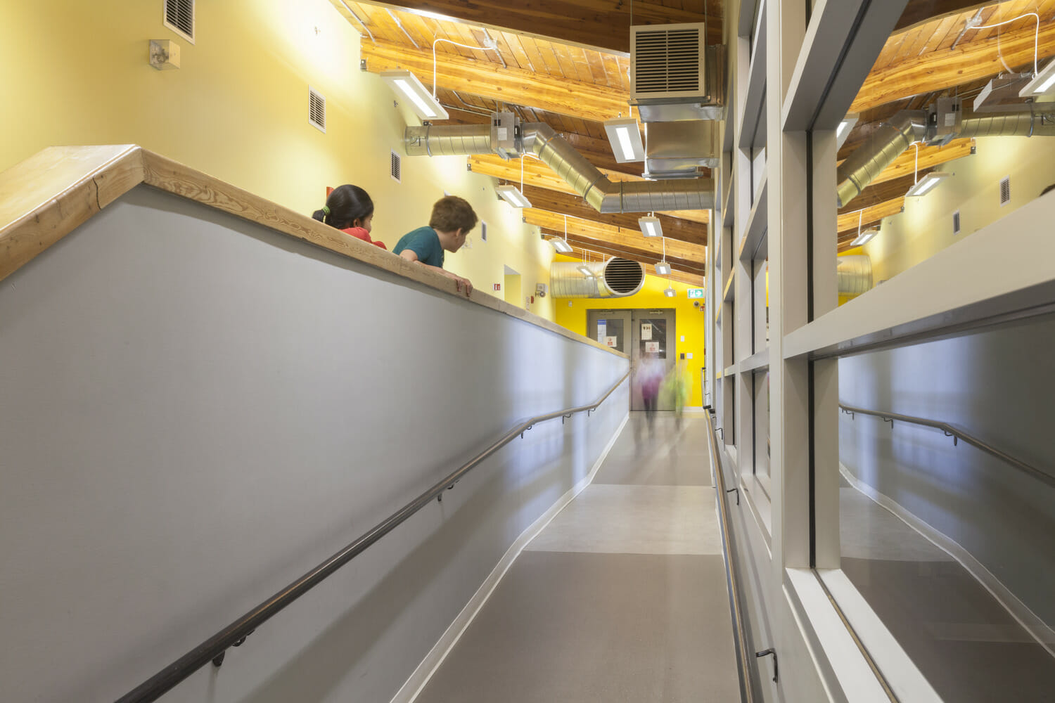 A hallway with two people walking down it.