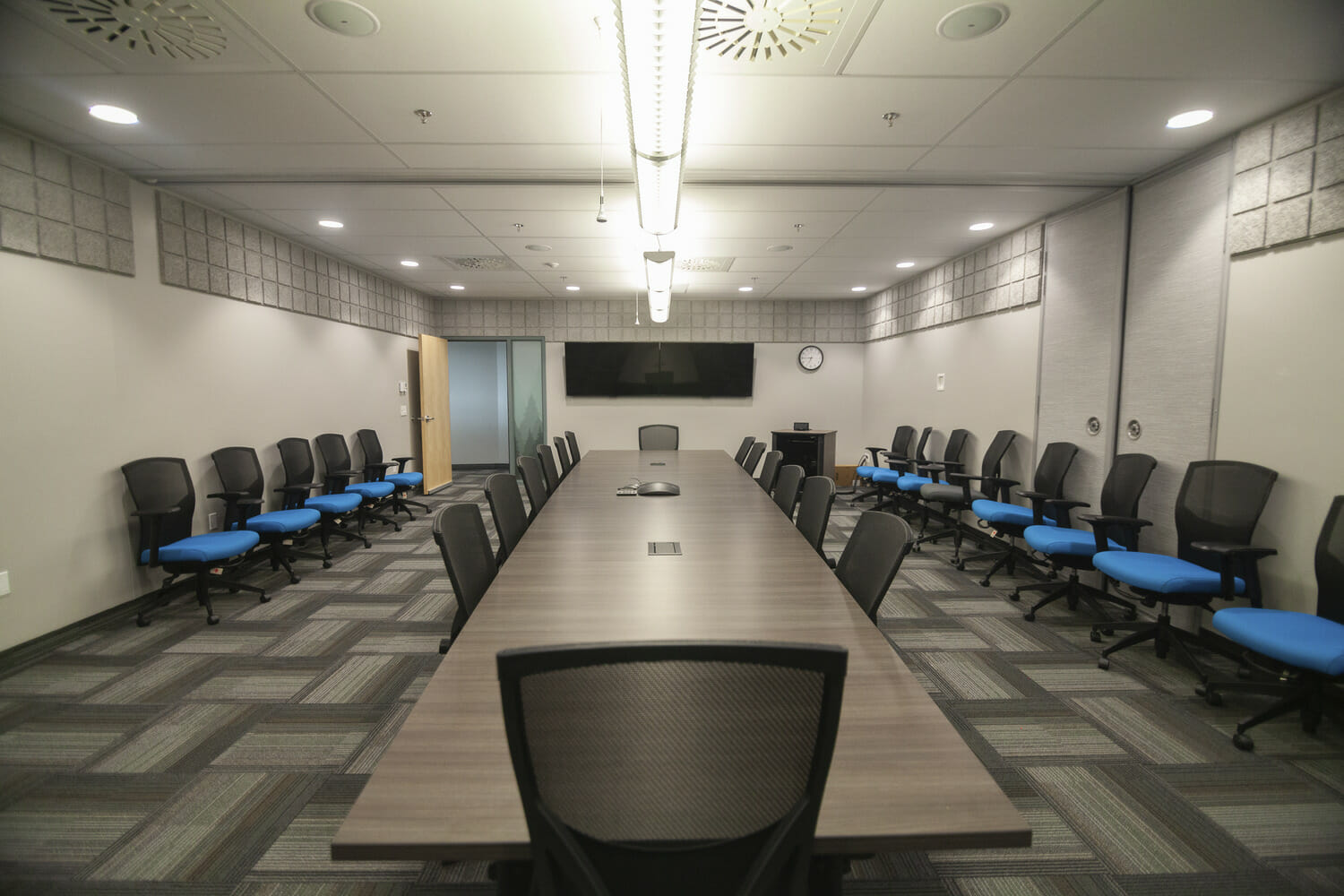 Une salle de conférence avec une longue table et des chaises.