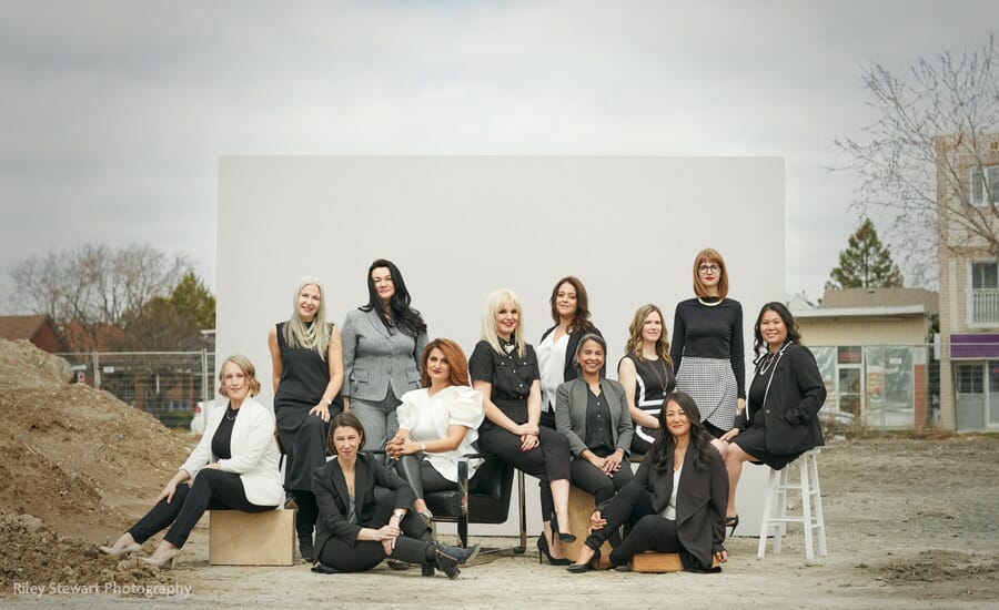 A group of women posing for a photo in front of a construction site.