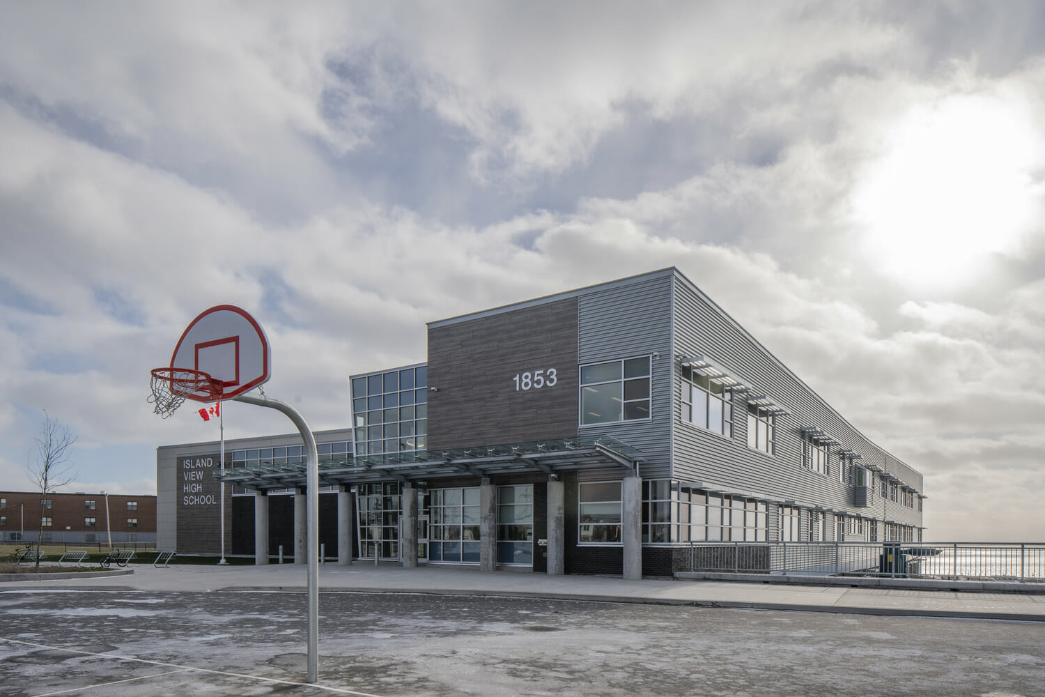 Un bâtiment avec un panier de basket devant.