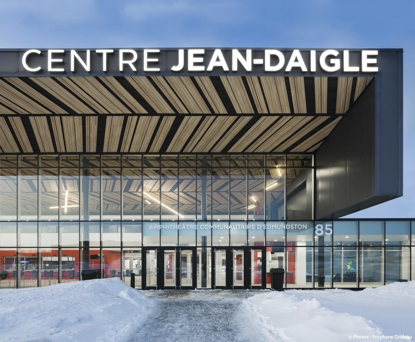 Un bâtiment avec de la neige dessus et une pancarte indiquant centre jean-daigle.