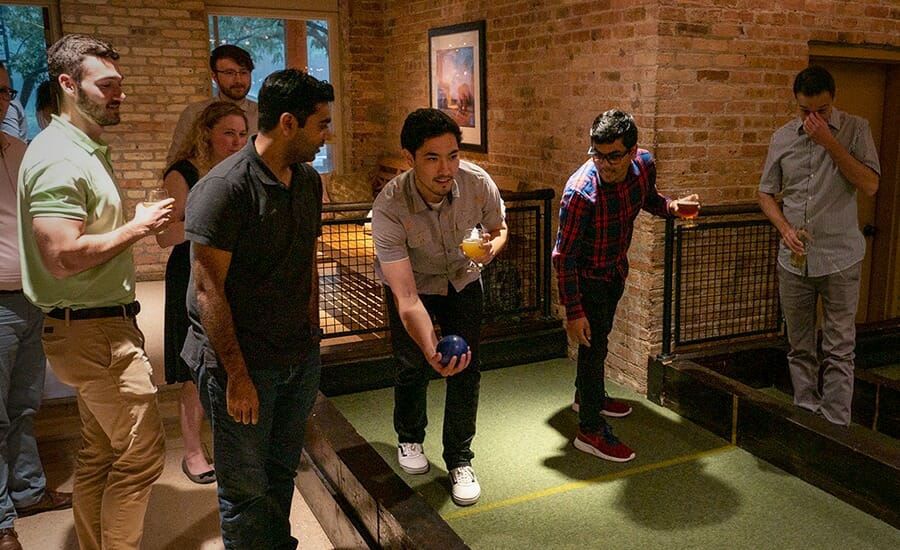 A group of people playing a game of shuffleboard, showcasing EXP culture.