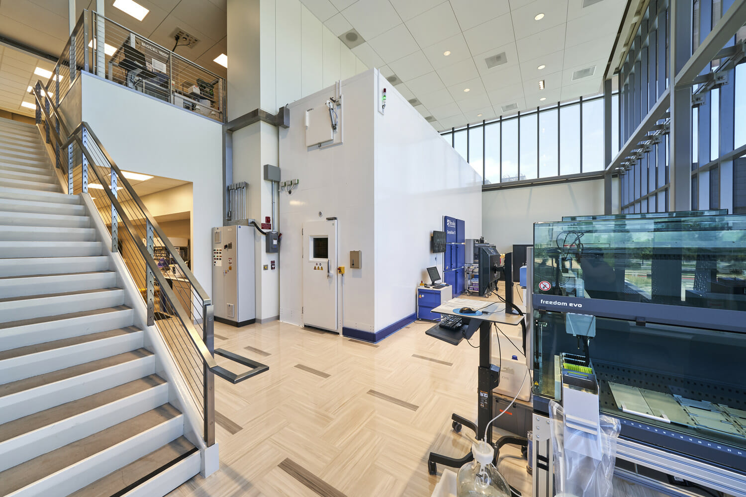 Une grande pièce avec un escalier menant à un laboratoire.