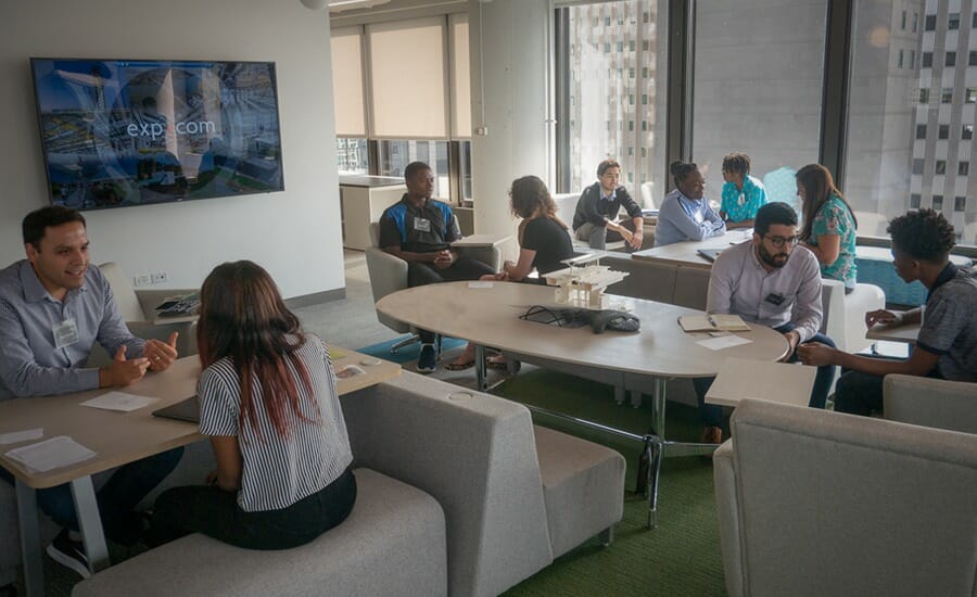 A group of people sitting around a table in an office.