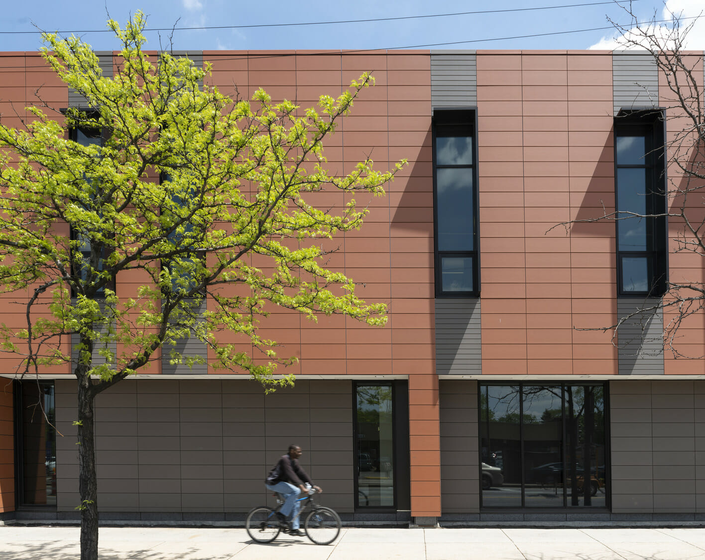 A person on a bicycle rides past a building.