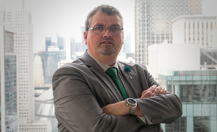 A man in a suit and tie standing in front of a city.