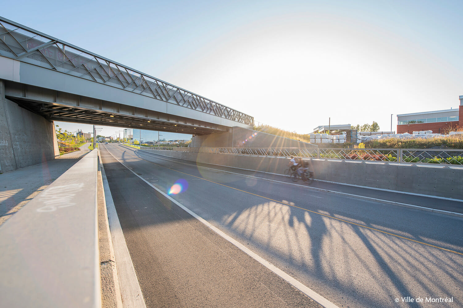 A person riding a bike under a bridge.